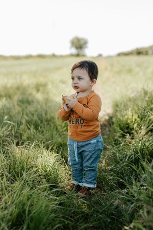 Child standing in field outside