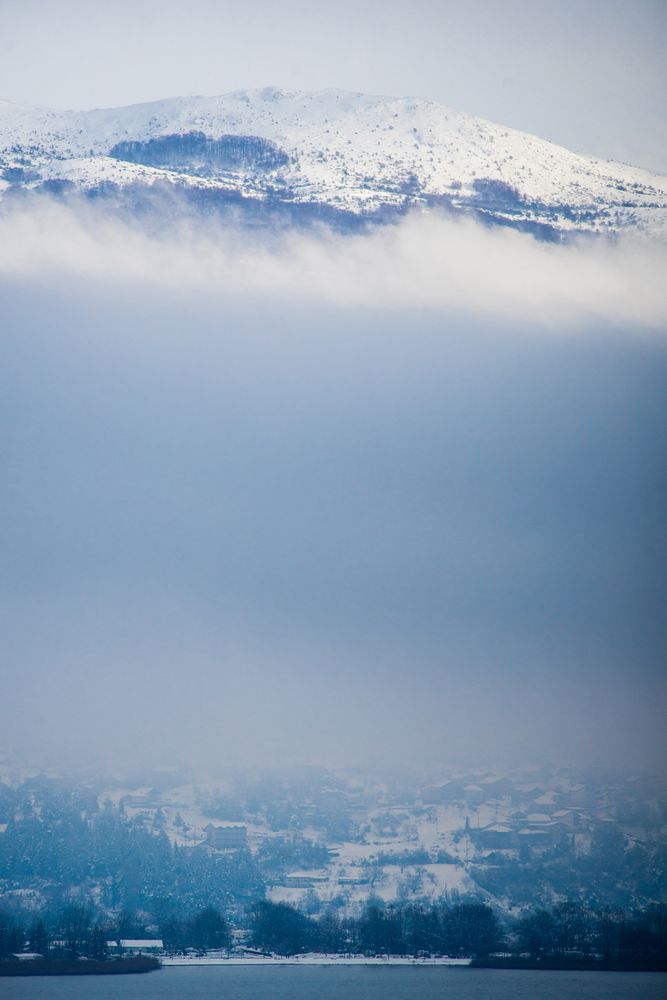 Amazing scenery of snowy mountain peak among lush clouds