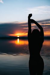 silhouette woman against sunset sky on beach
