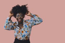Portrait of confident and happy Black woman dancing with her arms up
