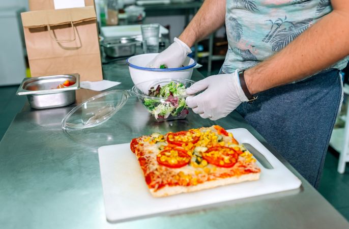 Unrecognizable cook preparing takeaway orders