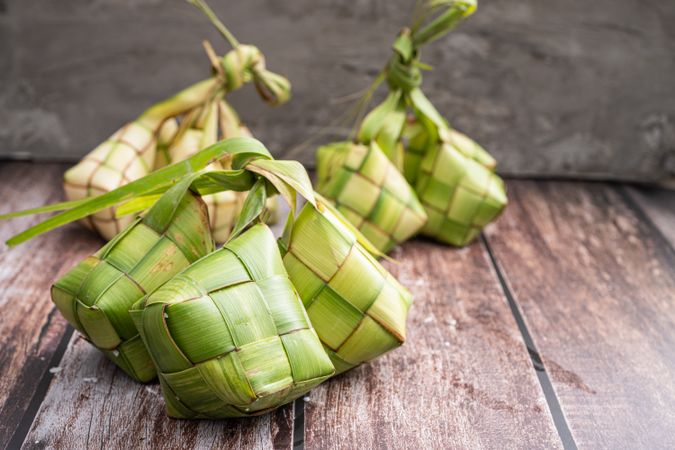 Uncooked ketupat filled with rice, placed on wooden surface