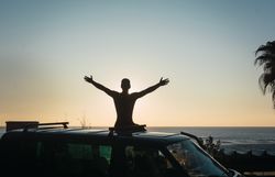 Man enjoying the sunrise in his camped van
