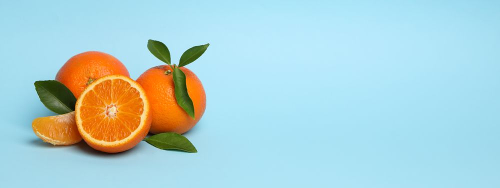 Ripe sweet mandarins on blue background, space for text