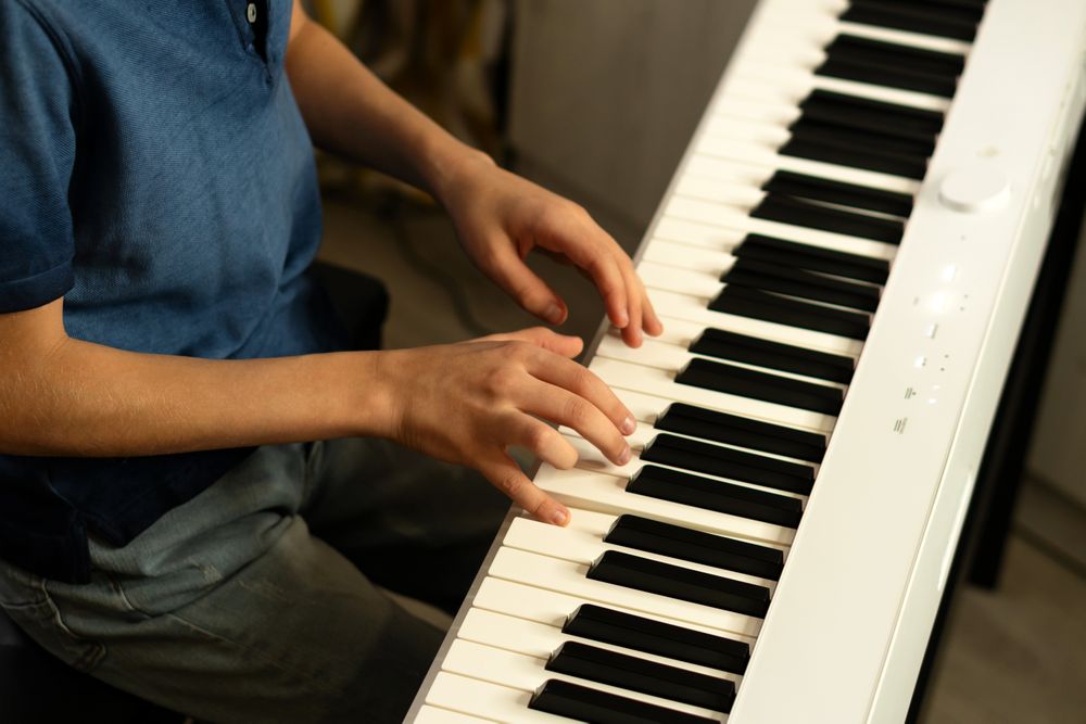 Side view boy's hands skillfully pressing piano keys.