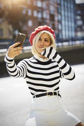 female in red beret taking selfie