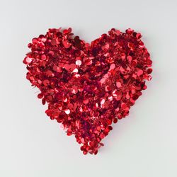 Red confetti shaped in heart on light background