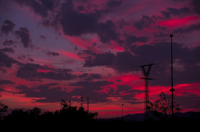 Utility poles against sunset sky