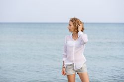 Young woman in water on shore