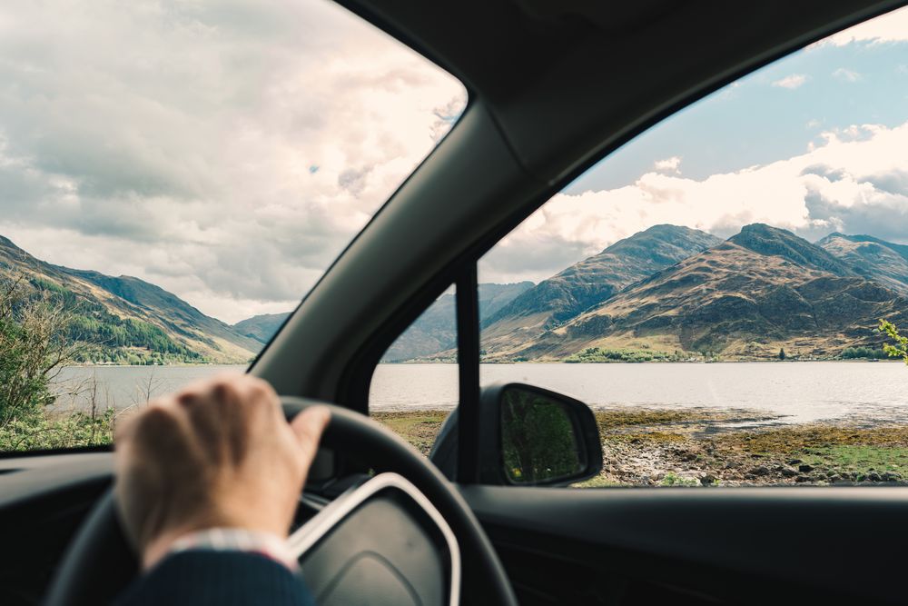 Driver in car with amazing landscape of mountains
