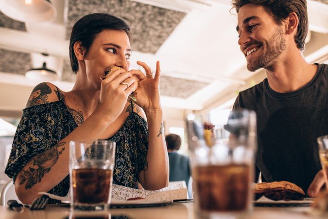 Woman hanging out with her boyfriend and eating burger