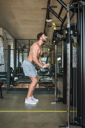 Guy using exercise machine in gym