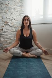 Woman in lotus pose meditating at home