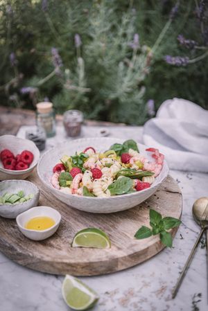 Tasty salad on wooden stand served on decorated table outside