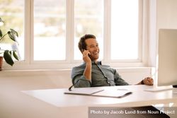 Relaxed businessman conversing over smart phone 5qrDJ4