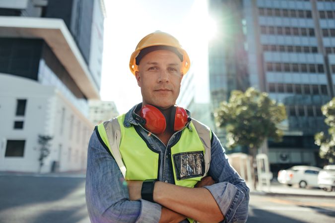 Confident construction worker looking at the camera wearing safety gear