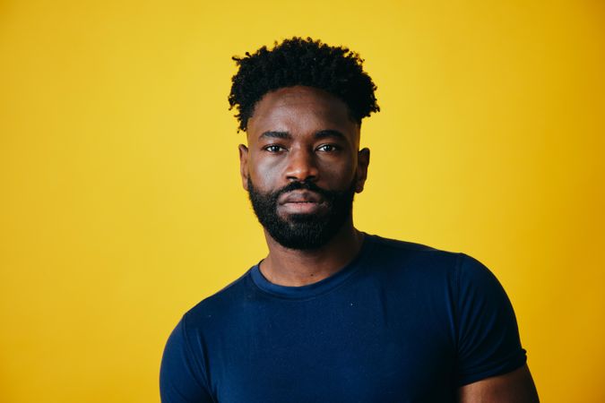 Portrait of serious Black man on yellow background
