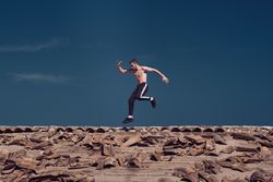 Active sportsman running and jumping on rooftop