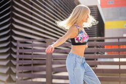 Side view of blonde woman dancing in the streets