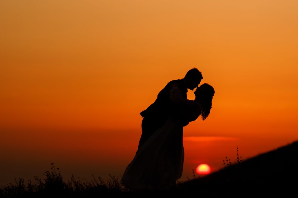 Bride And Groom Kissing In Love Sunset