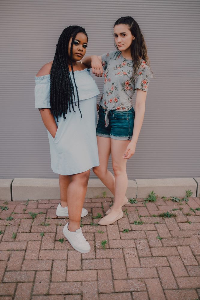 Multiethnic modern women embracing on street wall