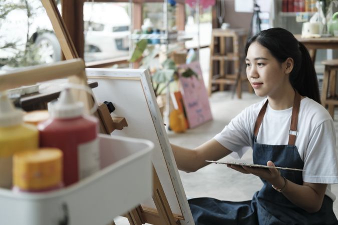 Crafting Inspiration. Female Artist Sketching and Painting in Workshop