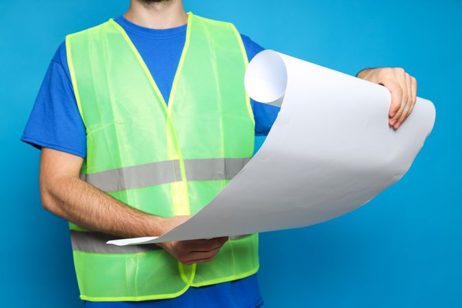 Civil engineer with blueprints on blue background
