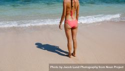 Young woman in bikini standing on the beach 4NEMOr