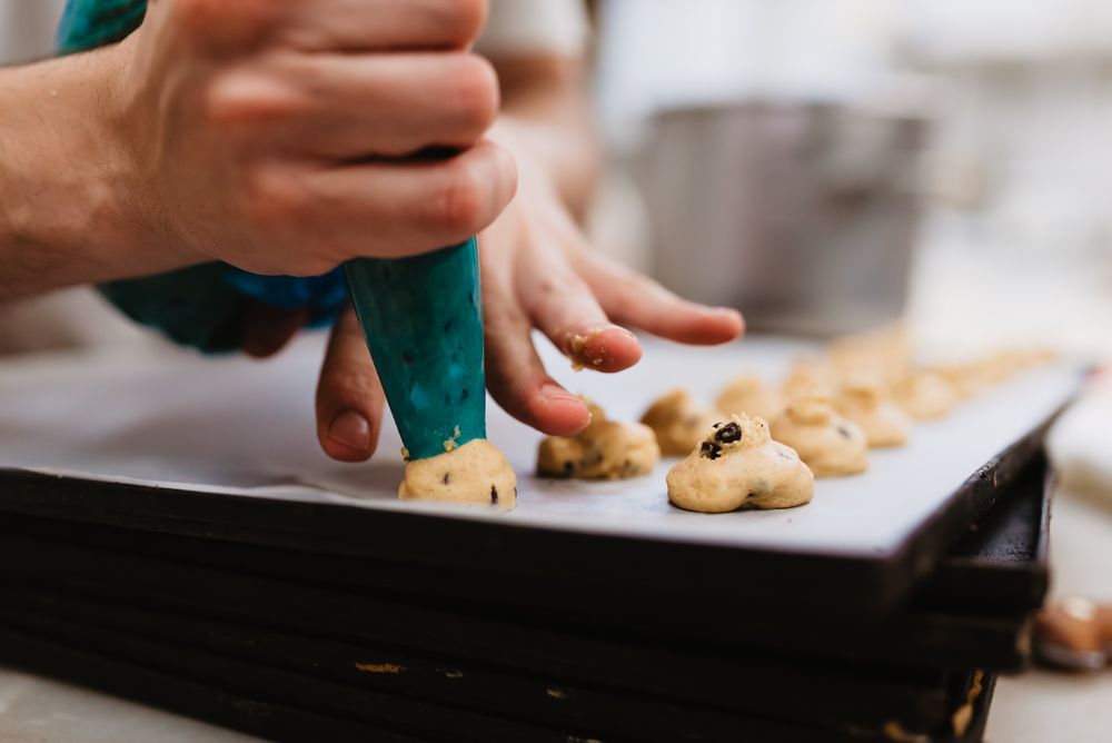 Crop baker squeezing dough on tray