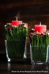 Side view of red Christmas candles and spice decor in vase on dark background beWol5