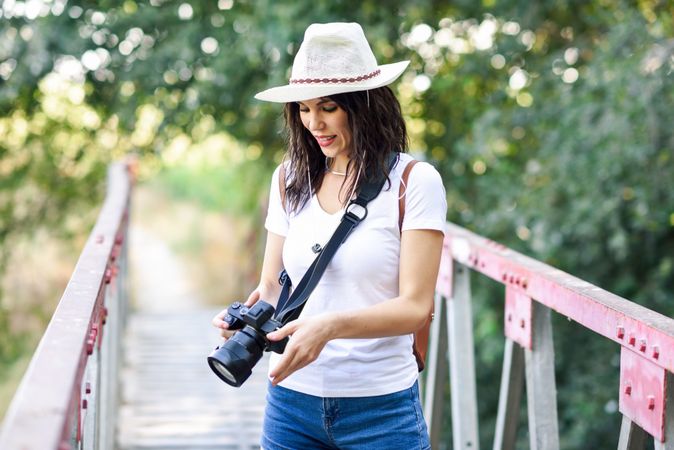 Woman walking with SLR camera checking view finder