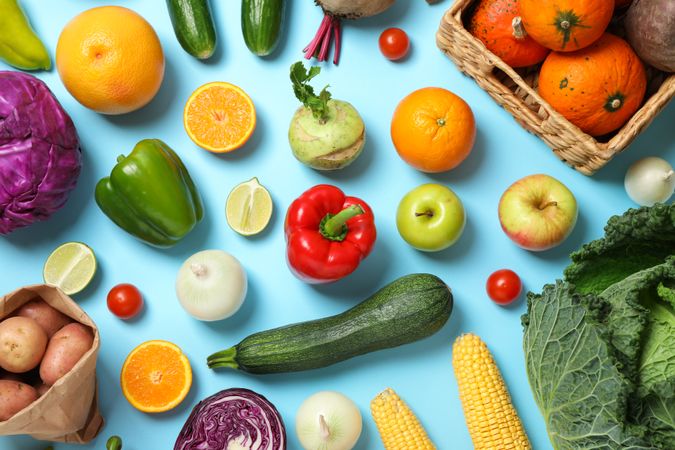Different vegetables and fruits on blue background, top view