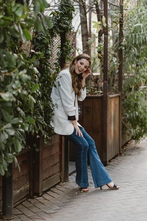 Woman sitting on planter in garden
