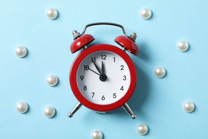 Alarm clock and beads on blue background. Happy new year