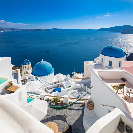 Square crop of blue topped domes over looking the Aegean Sea