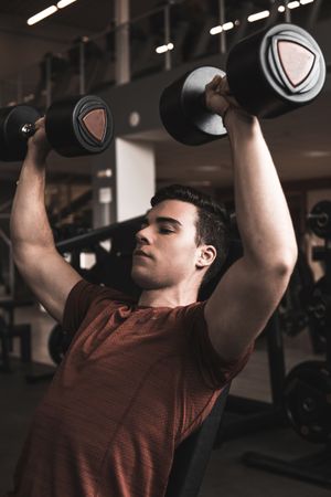 young fitness man doing weights