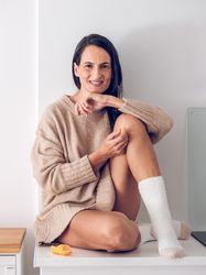 Smiling woman on counter with orange
