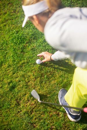 Back view of golf player adjusting the ball