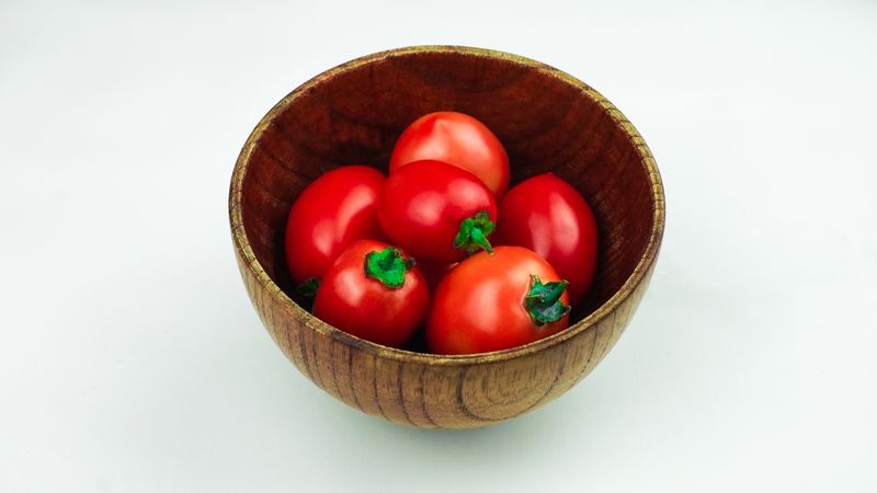 Pile of tomatoes in a wooden bowl
