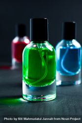 Green, blue and red perfume bottles in dark studio 0v3q1B