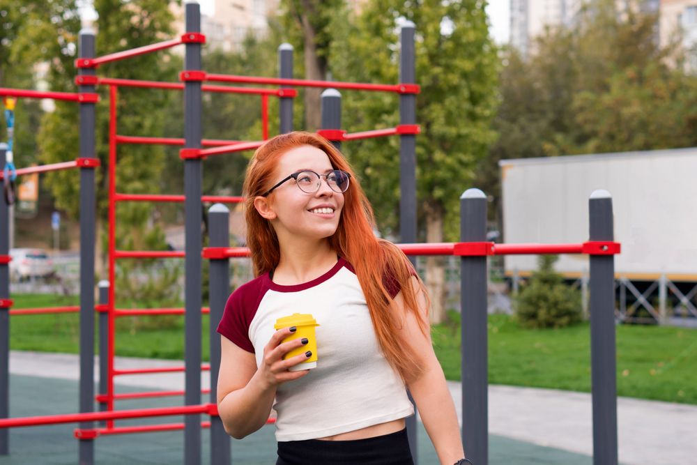Woman smiling and holding yellow cup while taking break