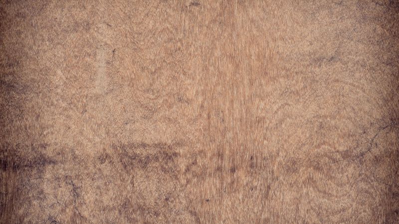 Natural dark brown wooden surface with organic grain texture and subtle pattern