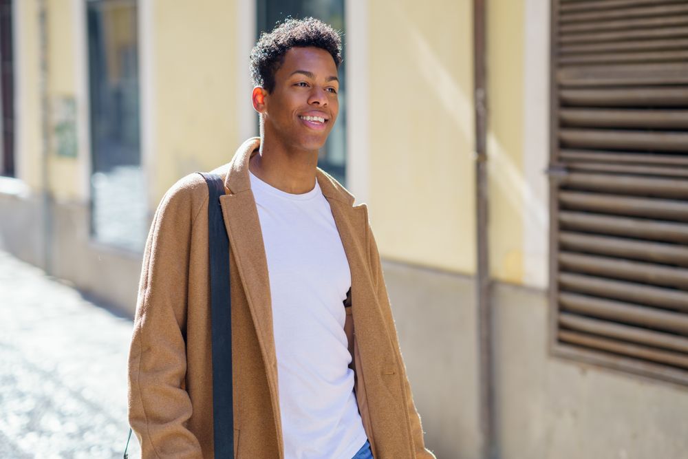 Smiling Cuban male strolling down street, copy space