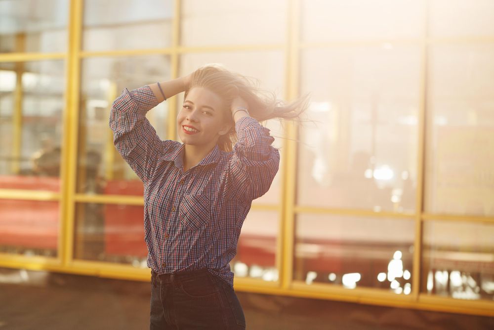 Smiling woman stands on the street of a windy city