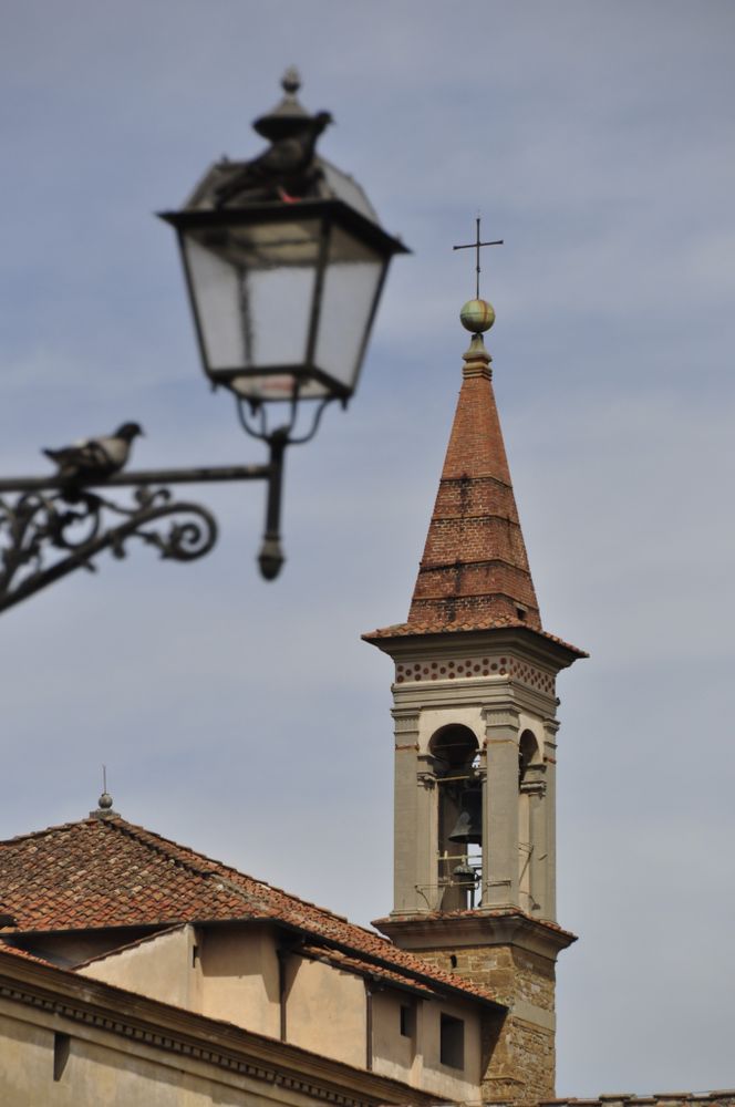 Bell tower of a church in Florence, Italy with foreground street lamp