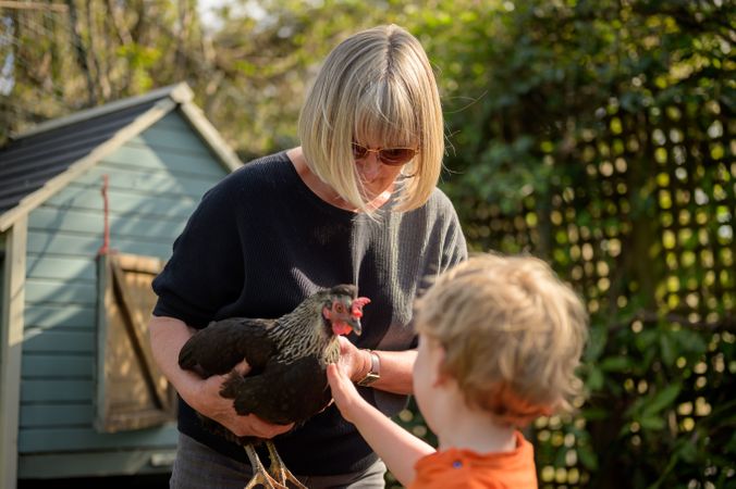 Woman showing rooster to child