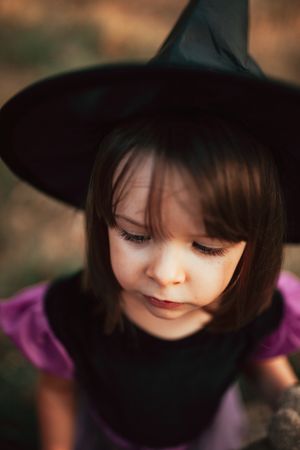 Girl girl with pensive expression in witch costume