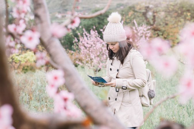 Tourist reading guide in spring countryside