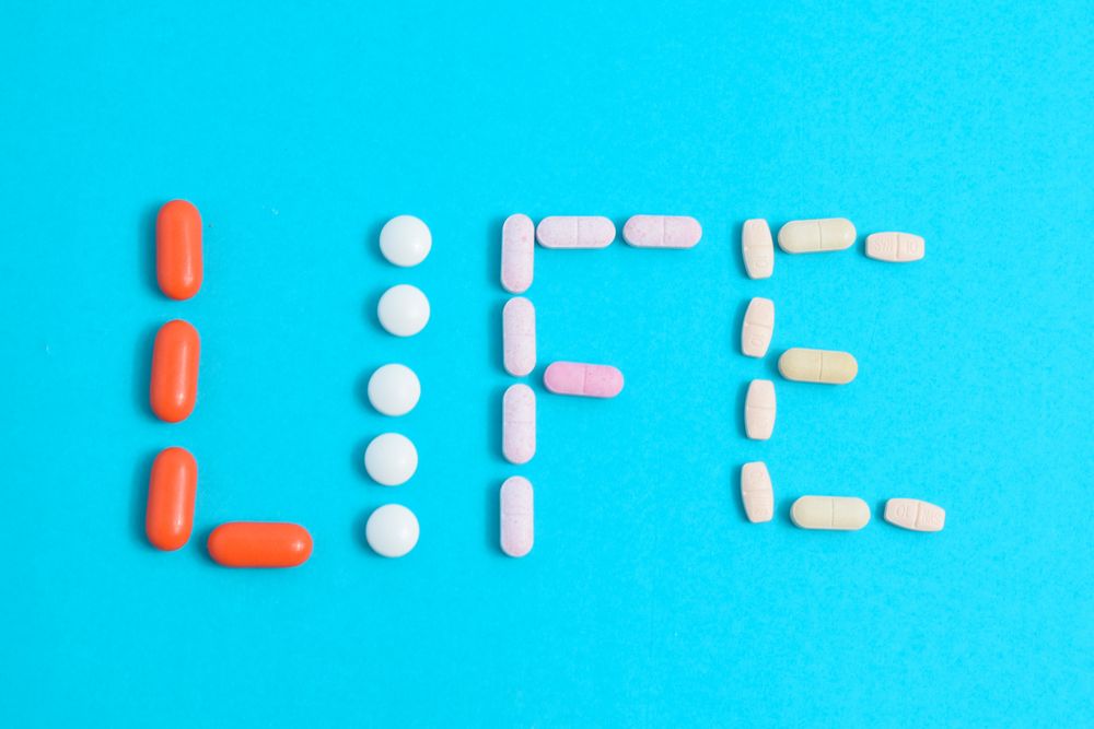 Top view of multiple pills making the word "LIFE"