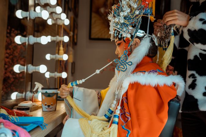 Chinese actress in her cultural outfit sitting beside mirror